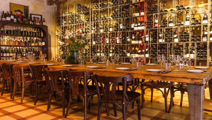 Bar à vin Brutal: longue table et mur de bouteilles